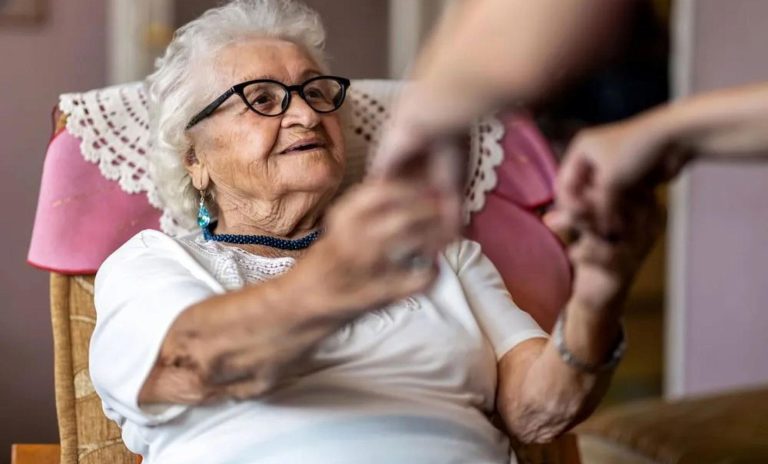 Veterans Home Service Caregiver Assisting Elderly Woman With Warm Smile